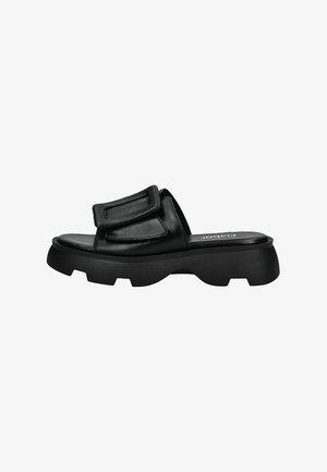 Black slide sandal with a chunky rubber sole, smooth leather upper, adjustable strap, and minimalistic design.