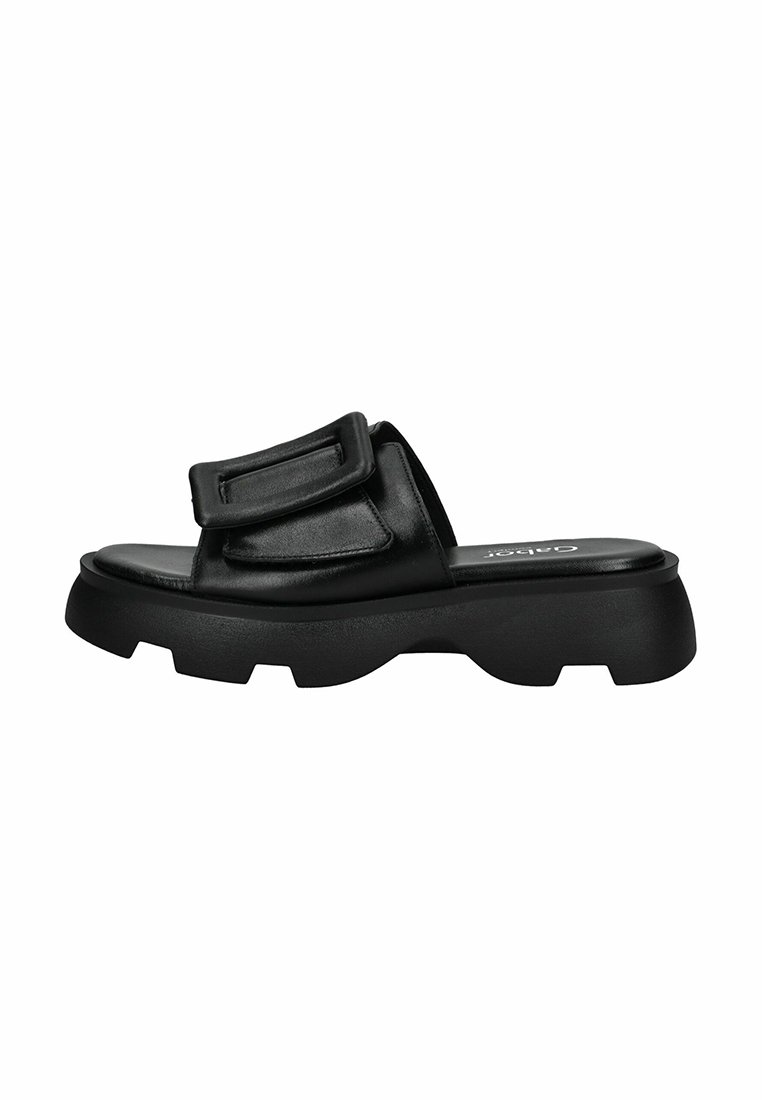 Sandale noire à glissière avec une semelle en caoutchouc épaisse, un dessus en cuir lisse, une sangle ajustable et un design minimaliste.