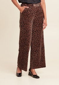 Leopardprint wijde broek van een zachte, gestructureerde stof, met een hoge taille en zijzakken, gecombineerd met zwarte hakken.