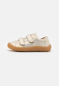 Jasnozłote dziecięce sneakersy z dwoma zapięciami na rzep, o okrągłym nosku, z brązową gumową podeszwą z teksturowanym wykończeniem.