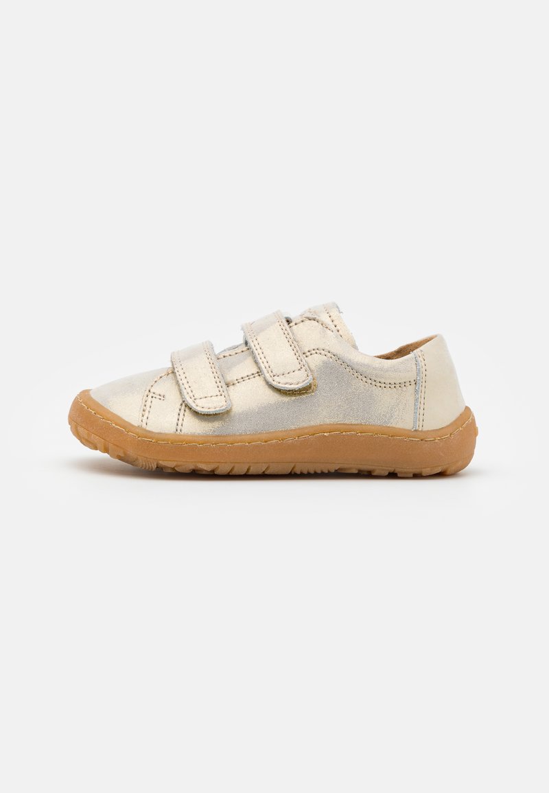 Jasnozłote dziecięce sneakersy z dwoma zapięciami na rzep, o okrągłym nosku, z brązową gumową podeszwą z teksturowanym wykończeniem.