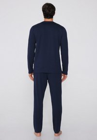 Top de manga larga en color navy y pantalones a juego, hechos de una tela suave. El diseño cuenta con un cuello redondo simple y un ajuste relajado.