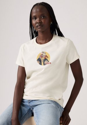 Cream-colored cotton t-shirt featuring a graphic print of a person in a yellow circle, with "LEVI'S" text near the hem.
