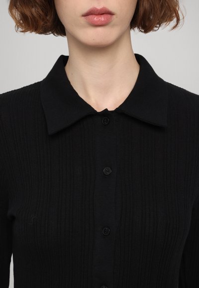 Schwarze gerippte Strickjacke mit klassischem Kragen, vorderer Knopfleiste und strukturiertem Strickstoff für zusätzliche Details.