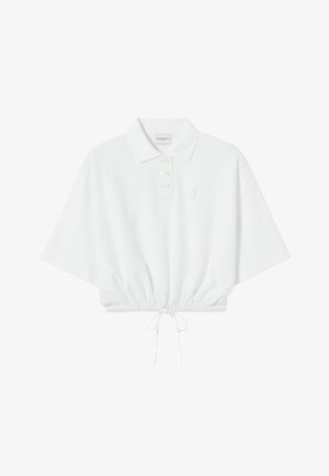 Polo blanc raccourci avec une patte de boutonnage, manches courtes, ourlet à cordon de serrage et broderie de logo discrète sur la poitrine. Texture de tissu doux.