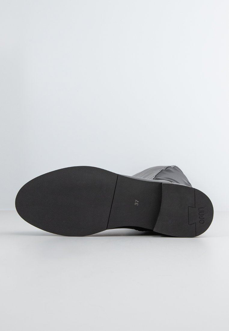 Suola in gomma nera di un stivale con leggera trama. Il design presenta una parte superiore liscia e una forma affusolata, con la taglia contrassegnata come 37 sulla suola.