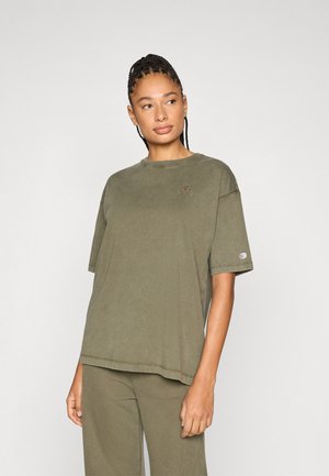 Tricou larg de culoare verde măsliniu, confecționat din bumbac moale, cu decolteu rotund și mâneci scurte, având un logo mic pe piept și pe mânecă.