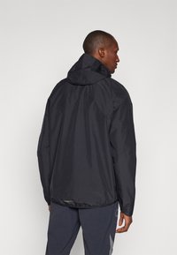 Schwarze, leichte Kapuzenjacke aus glattem Material, mit elastischem Saum und minimalistischem Design. Verfügt über eine mit Reißverschluss verschlossene Seitenasche.