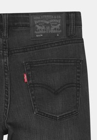Levi's 511™ farkut mustasta denimista sisältävät klassisen viiden taskun suunnittelun, nahkapaikan logolla ja punaisen tabin takataskussa.