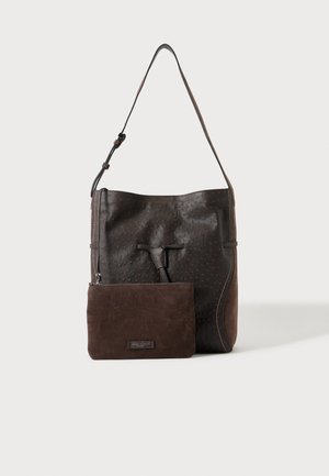 Borsa a tracolla in pelle marrone scuro testurizzata con una piccola pochette con zip abbinata posta davanti su uno sfondo chiaro e semplice.