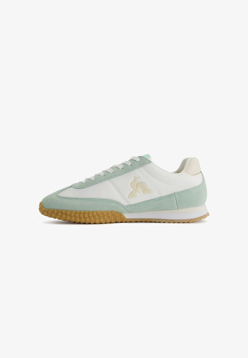 Zapatillas en verde menta y blanco con materiales de ante y cuero, suela de goma texturizada y un logo embossado en el lateral.