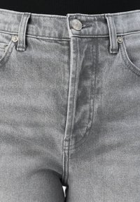 Grijze denim jeans met een hoge taille, voorzien van een klassieke knoopsluiting, zichtbare stiksels en twee voorzakken. Gestructureerde stof.