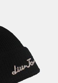 Berretto a coste nero lavorato a maglia con logo argentato decorato sul davanti. Presenta una trama morbida e una forma aderente.