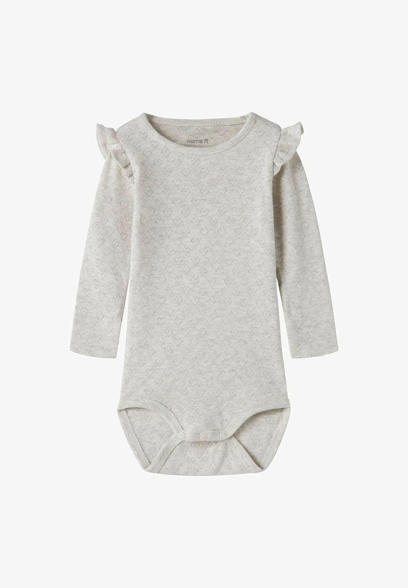 Body bébé beige à manches longues avec petits motifs en forme de cœur et détails à volants aux épaules, avec boutons-pression en bas.