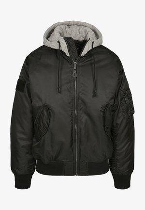 Zwarte bomberjack met een grijze capuchon, ritssluiting aan de voorkant en geribbelde manchetten. Heeft zijzakken en een patch op de linker mouw. Soepele textuur.