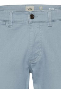 Lichtblauwe slim-fit broeken van katoen met een gladde textuur. Voorzien van een knoopsluiting, standaardzakken en subtiele stikdetails.