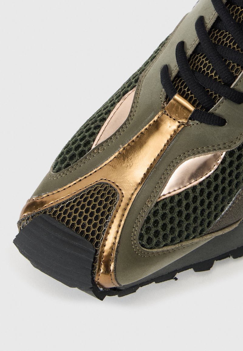 Groene mesh sneaker met bronzen accenten, gestructureerd oppervlak, zwarte veters en een rubberen zool, met een gestroomlijnd en sportief ontwerp.
