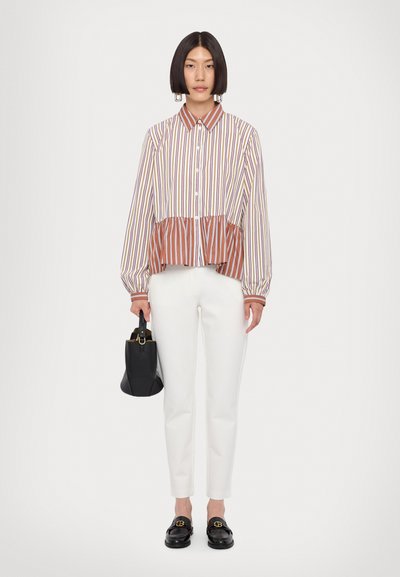 Striped button-up blouse with balloon sleeves in white, purple, and brown, paired with tailored white pants and a small black handbag.