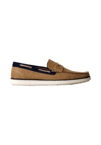 Mocassin en daim beige avec bordure bleu marine, surpiqûres mocassin, semelle blanche en caoutchouc et détail de bride à pièce, présenté en profil latéral sur fond blanc.