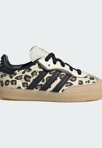 Zapatillas con estampado de leopardo y detalles en negro, con una parte superior de cuero texturizado y tres franjas negras, complementadas con una suela de goma.