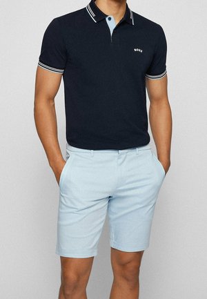 Marineblaues Poloshirt mit gestreiftem Kragen und hellblauen Akzenten, kombiniert mit hellblauen Shorts, mit schlanker Passform und glatter Textur.