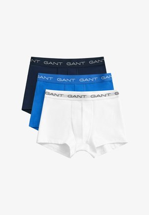 Tre paia di boxer da uomo del marchio GANT in bianco, blu e blu scuro, impilati e distesi.