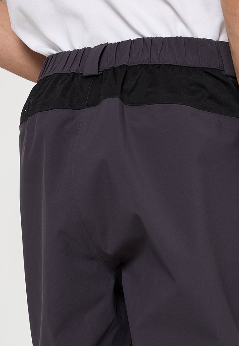 Elastische short in donkerpaars met een zwarte tailleband. Soepele textuur en minimaal ontwerp, met subtiele stikdetails.