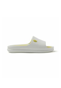 Chancla blanca hecha de material suave, con una plantilla amarilla y un pequeño adorno en forma de pez amarillo en la parte superior. Diseño plano.