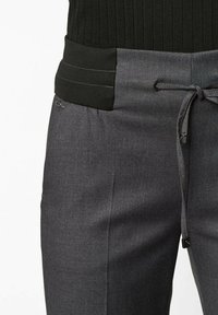 Lightweight black and gray trousers with a textured waistband, drawstring closure, and subtle pocket detailing.