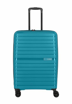 Harde draagbare koffer in teal met horizontale ribbels, zwarte handgreep en spinwielen. Ritsluiting en logo aan de voorkant weergegeven.