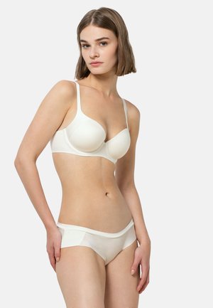 Vitt set med behå och bikini i slät tyg, sömlös design, justerbara band och midja med låg skärning med minimalistisk silhuett.