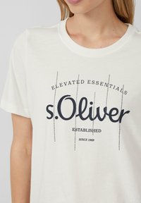 White cotton t-shirt with a relaxed fit, featuring a black graphic logo and text "s.Oliver Elevated Essentials Established since 1969."