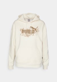 Krämfärgad hoodie gjord av mjukt tyg, med en framficka och en stor tryckt Puma-logga med blommiga detaljer i beige.