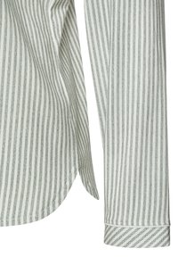 Leichte, gestreifte Bluse mit weißen und grünen Linien; verfügt über einen abgerundeten Saum und Knopfmanschetten. Baumwollstoff mit weicher Textur.