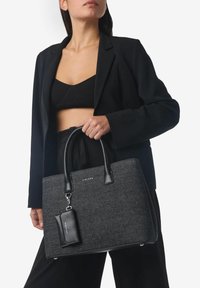 Borsa a tracolla nera con tessuto texture e dettagli in pelle nera liscia, caratterizzata da due manici robusti e una piccola pochette removibile.