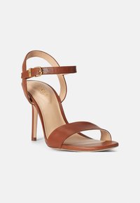 Brown leather high-heeled sandal with a narrow ankle strap, open toe design, smooth texture, and a gold buckle accent.
