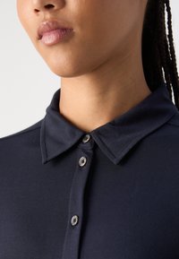 Marine poloshirt met een kraag, voorzien van een knopenlijst met grijze knopen en een gestructureerde stof voor een gladde afwerking.