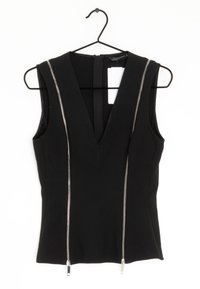 Zwarte mouwloze top met een diepe V-hals en twee zilveren ritsaccenten aan de voorkant. Gemaakt van een gladde stof, is het aansluitend met een verborgen rits aan de achterkant.