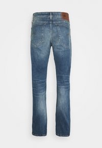 Jeans in denim di un blu medio con gamba dritta, due tasche posteriori e una patch in pelle marrone sulla vita.