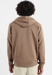 Sweat à capuche marron avec cordon de serrage, poignets et ourlet côtelés. Tissu doux avec une texture lisse, orné d'un logo sur l'épaule.