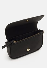 Bolso cruzado de cuero negro con acabado texturizado, herrajes dorados, compartimento con cremallera y cierre a presión. Abierto para mostrar el interior.