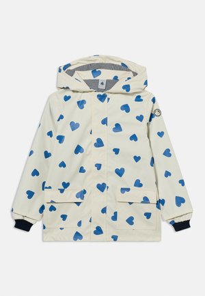 Børnecreme hætte-regnfrakke med blå hjerteprint, forlommer og sorte elastiske manchetter.