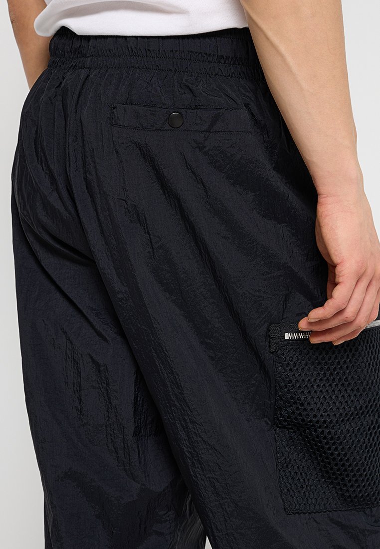 Pantaloni cargo leggeri neri con finitura testurizzata, dotati di una vita elasticizzata e dettaglio con tasca in rete sul lato.
