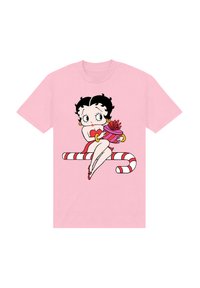 Růžové tričko s kreslenou postavičkou s �černými kudrnatými vlasy, která drží dárek a sedí na pruhované cukrové holi.