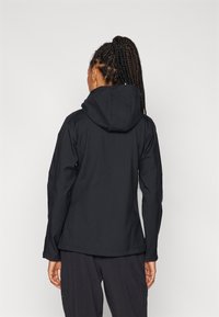 Black hooded jacket with long sleeves and a sleek design. Features a smooth texture and minimal stitching, suitable for active wear.