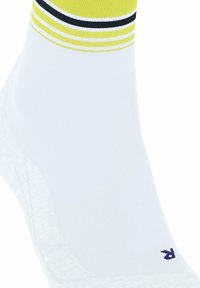 Biała sportowa skarpetka o prążkowanej fakturze, z żółtymi i czarnymi paskami na górze oraz małym niebieskim logo z boku.