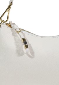 Hvid læderhåndtaske med en struktureret overflade, guldfarvede metaldele, lynlås og en aftagelig rem med accentdetaljer.