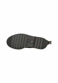Semelle extérieure de sneaker en caoutchouc noir avec un motif de relief, des bords lisses et un logo imprimé aux couleurs du drapeau italien.