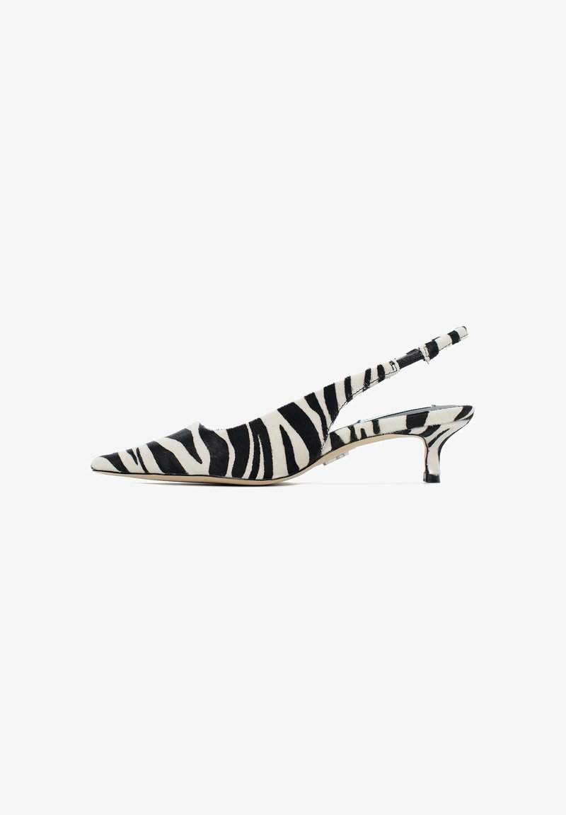 Chaussure slingback en imprimé zèbre noir et blanc avec un bout pointu et un petit talon. Présente une texture lisse et une sangle réglable.
