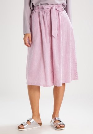 Mid-length pink and white striped skirt with front buttons and tied waist, paired with silver buckle sandals on a neutral background.